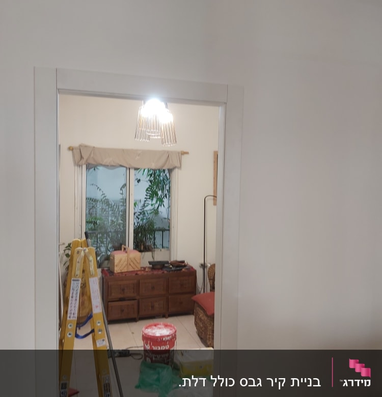 סולם, דלי צבע, מברשת ויריעת ניילון על הרצפה